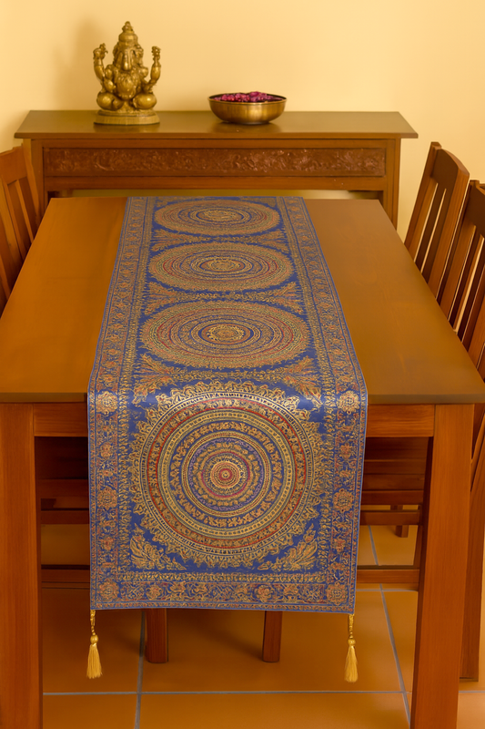 Blue Banarasi silk brocade table runner measuring 72x16 inches, featuring intricate gold mandala motifs and floral patterns. Ideal for dining table decor, festive settings, or gifting, the runner showcases traditional Indian craftsmanship with a luxurious sheen and ornate border detailing.